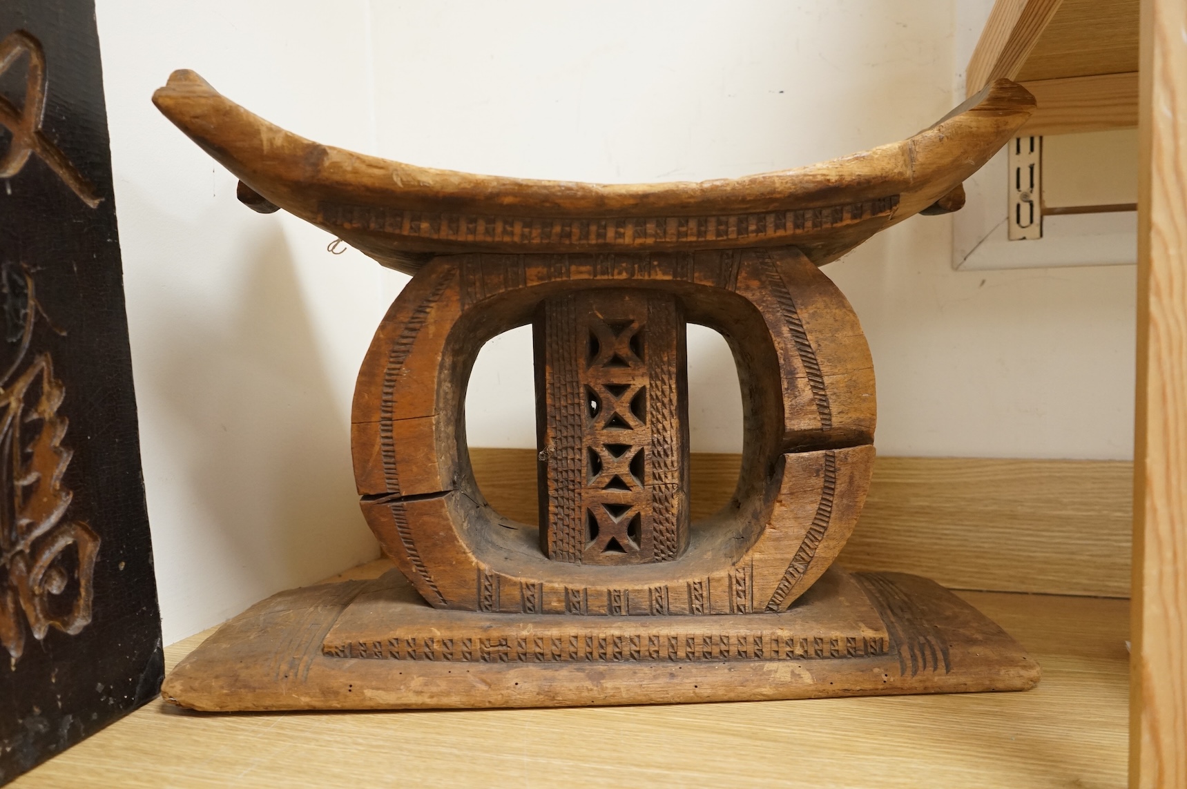 An Ashanti carved wood stool together with a similar headrest, tallest 41cm